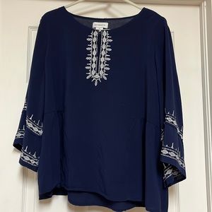 Women’s dark blue blouse with wide bell sleeves.